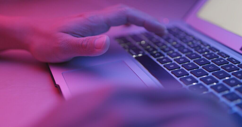 Capa do artigo "como executar um script usando GitHub Actions" com um foco em um teclado de notebook e a cor violeta.