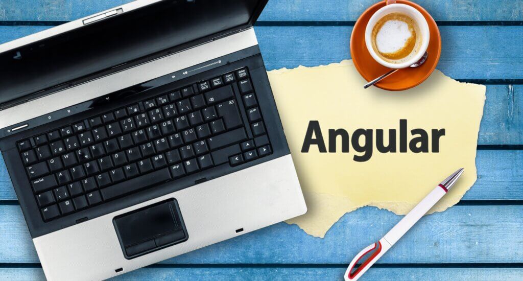 Capa artigo aprender Angular em que vemos um notebook, um papel escrito "Angular", uma caneca e um copo de café com creme.