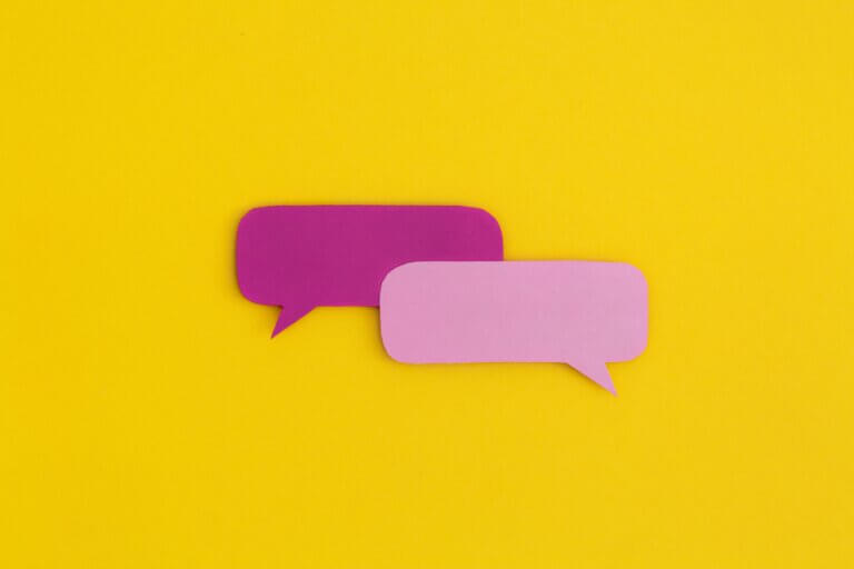 Caa do artigo sobre Comunicação não Violenta que mostra dois balões de dialogo cor de rosa em um fundo amarelo.