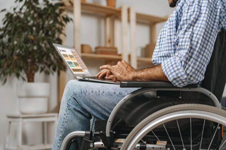 Capa do artigo sobre acessibilidade na web em que vemos um homem em uma cadeira de rodas e um notebook no colo.