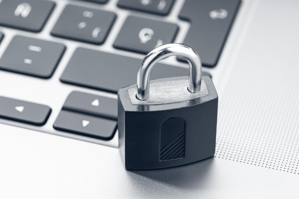 Capa do artigo “Infraestrutura como código: 8 práticas ruins de segurança em scripts para evitar” onde temos um cadeado prateado fechado em cima de laptop moderno.