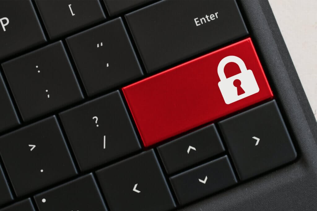 Capa do artigo sobre o programa Security Champions, onde em um teclado com teclas pretas, existe uma tecla vermelha com um cadeado fechado,