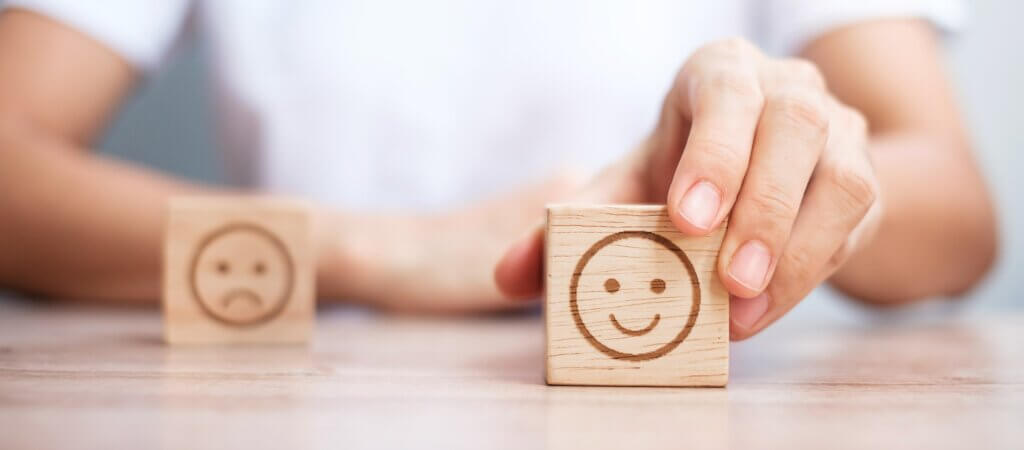 Capa do artigo sobre Satisfação na Engenharia de Software com um bloco com emoji feliz em primeiro plano.